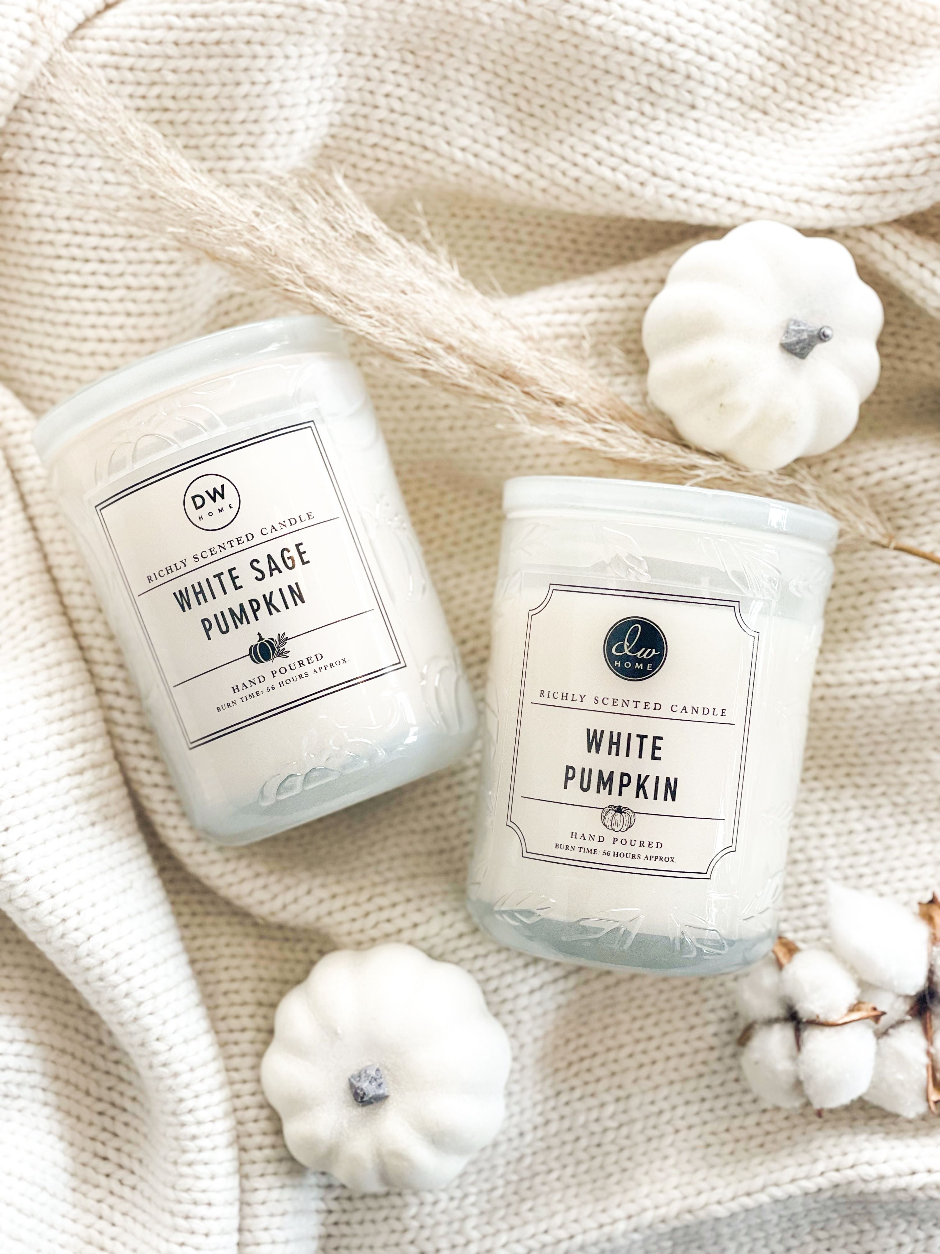 white premium signature candles on a white blanket with white pumpkin accents